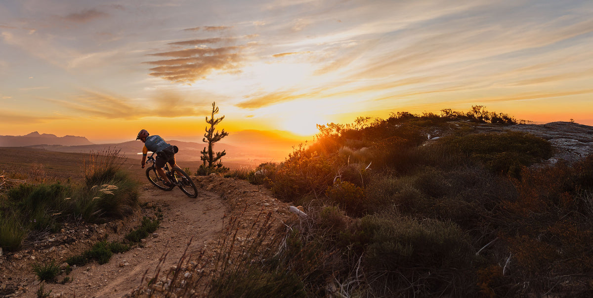 Mountainbiker op een Zuid-Afrikaanse trail bij zonsondergang